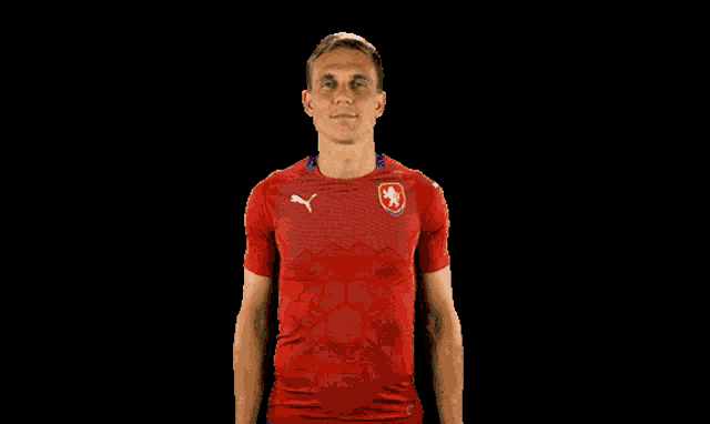 a man in a red shirt with a lion on it is giving a thumbs up