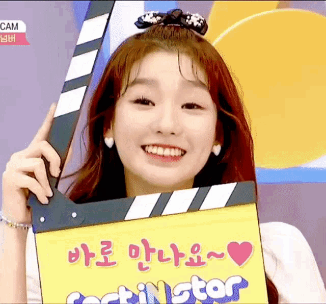 a girl is smiling while holding a clapper board that says ' casting star ' on it