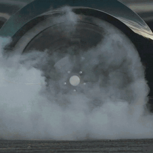 smoke is coming out of a car tire with a white center