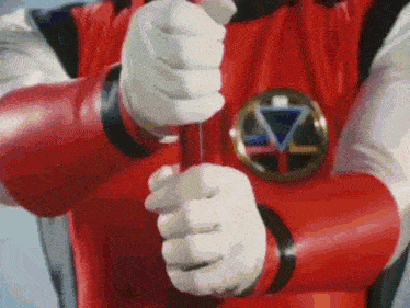 a close up of a person holding a red object in their hand .