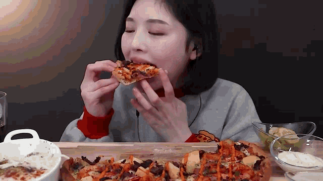a woman is eating a slice of pizza .