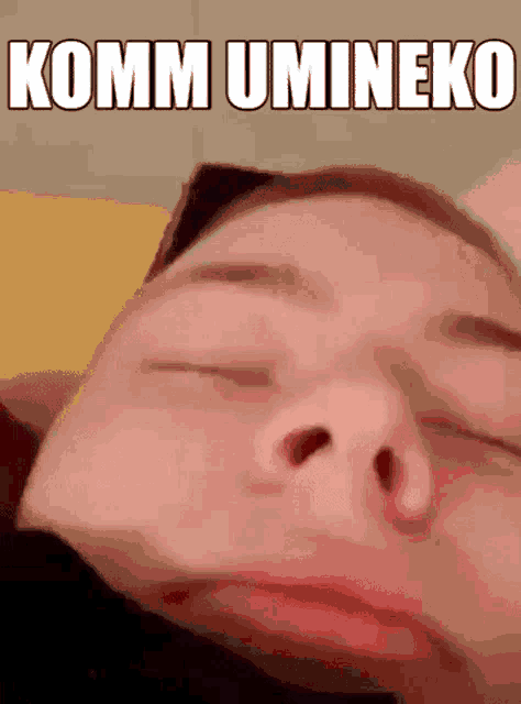 a close up of a person 's face with the words `` komm umineko '' written on it .