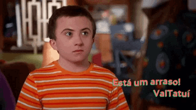 a young boy in an orange and white striped shirt says esta um arrasol