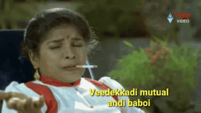 a woman smoking a cigarette with the words " veedekkadi mutual andi baboi " written on the bottom