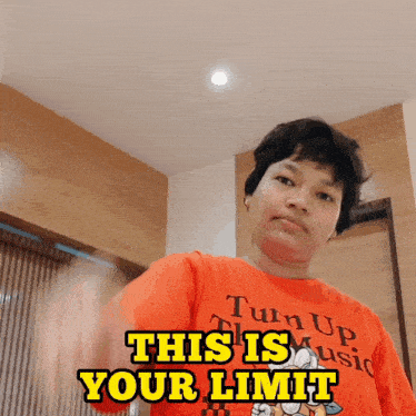 a man wearing an orange shirt that says turn up music