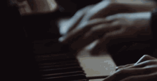 a close up of a person playing a piano in the dark .