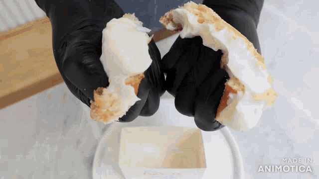 a person wearing black gloves is holding a donut in their hands with the words made in animotica below it