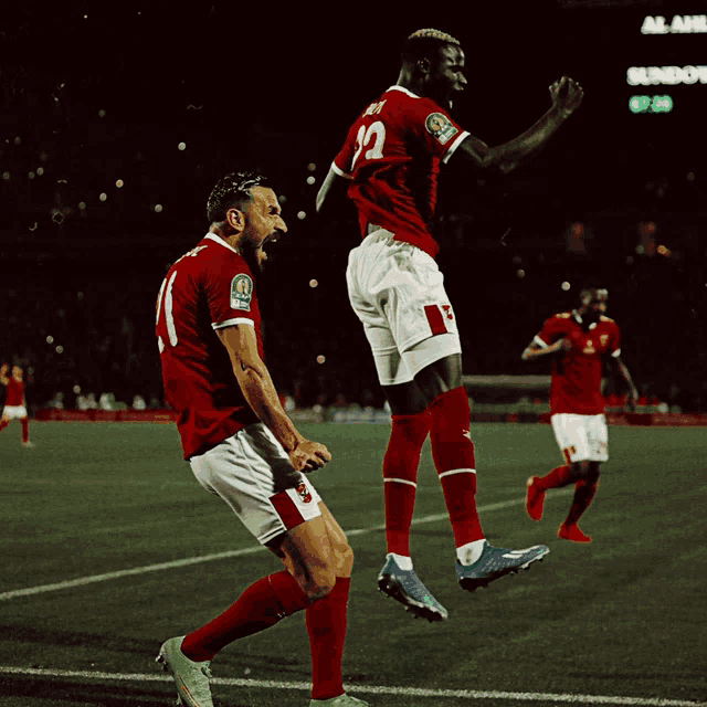 two soccer players are jumping in the air while one has the number 12 on his jersey
