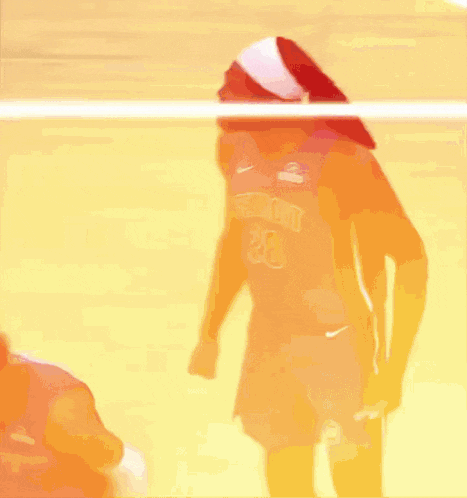 two basketball players are standing next to each other on a court . one of the players is wearing a detroit jersey .