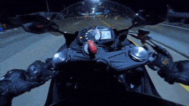 a motorcycle is driving down a highway at night and the tachometer reads 26