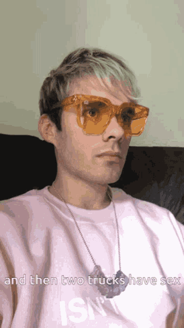 a man wearing sunglasses and a pink shirt with the words and then two trucks have sex