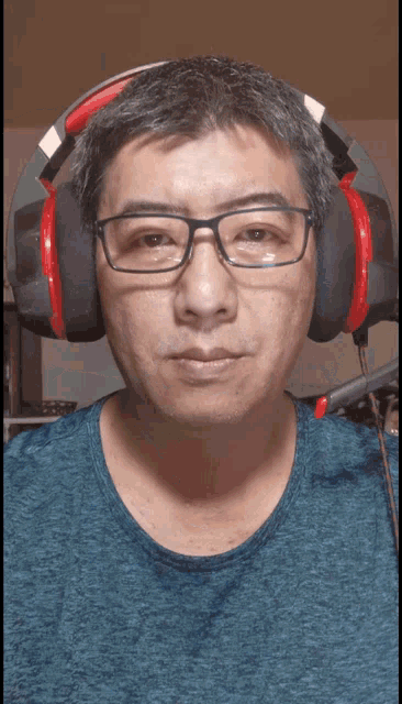a man wearing glasses and headphones with a blue shirt on