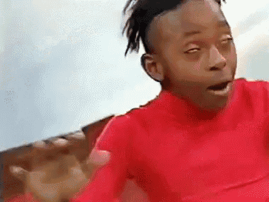 a young boy in a red shirt is making a funny face with his eyes closed and his mouth open .