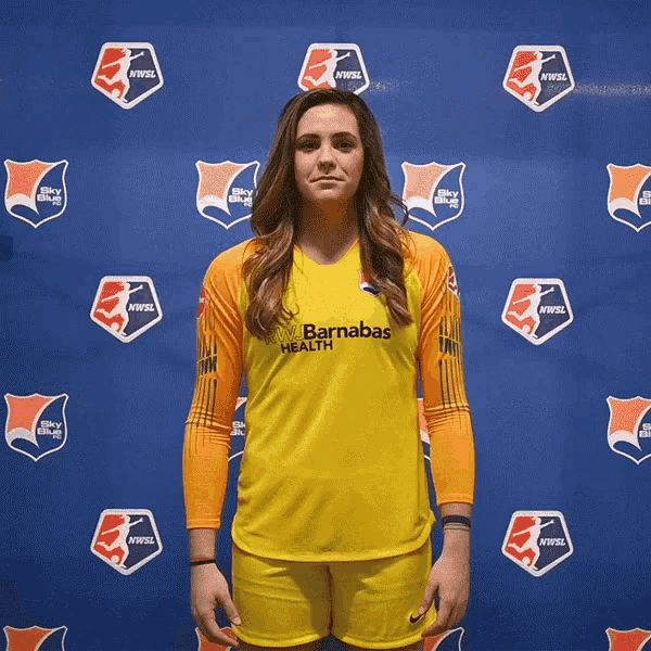 a woman in a yellow barnabas health jersey