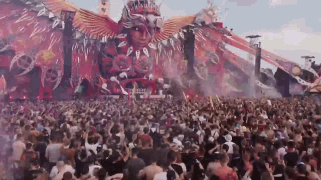 a large crowd of people are dancing at a music festival .