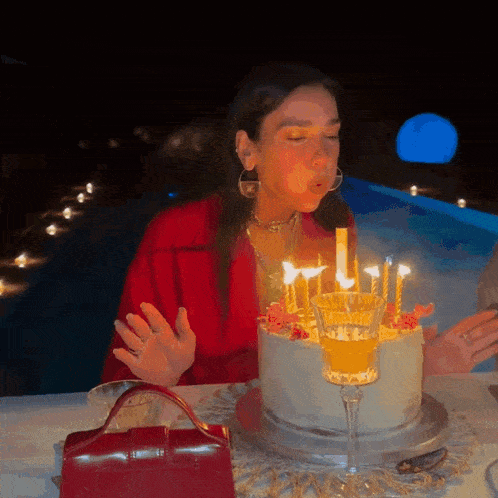 a woman blows out candles on a cake