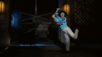a man in a mask is dancing in front of a closed door