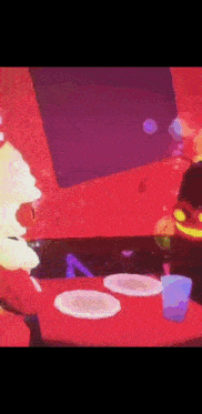 a table with plates and cups on it in a red room