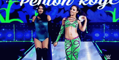 two women are walking down a stage holding hands .