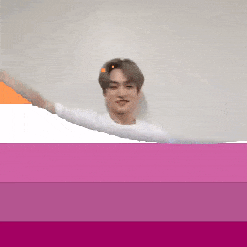 a man in a white shirt is standing in front of a pink and white background .