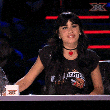 a woman wearing a t-shirt that says foo fighters is smiling