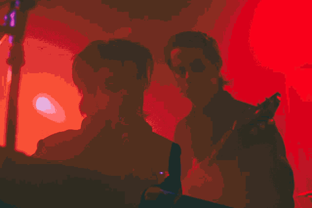a man playing a guitar in a red light