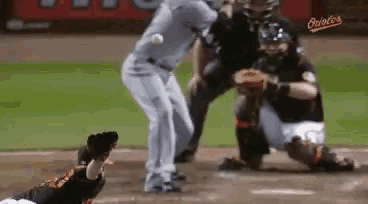 a baseball player is trying to catch a ball while a catcher looks on .