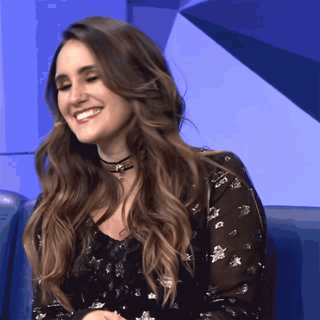 a woman wearing a choker and a black dress smiles