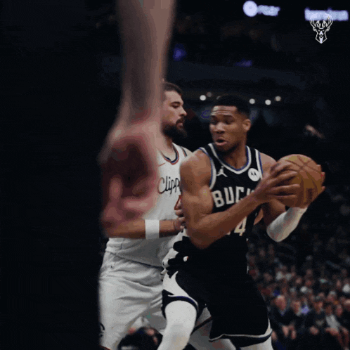 a basketball player with the number 34 on his jersey is dribbling the ball