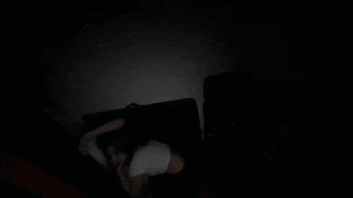 a blurred image of a person in a dark room talking on a cell phone