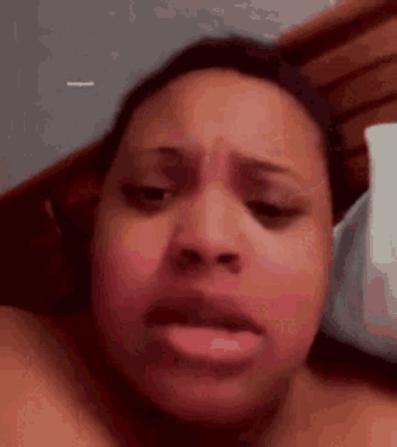 a close up of a woman 's face while laying in bed .
