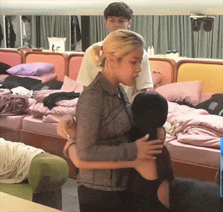a woman hugging another woman in front of a mirror