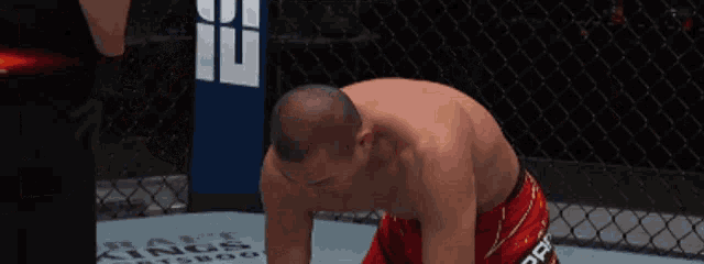 a man is kneeling down in a boxing ring with a sign that says kings on it
