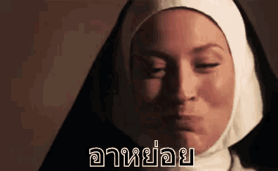 a nun is making a funny face with her eyes closed in a close up .