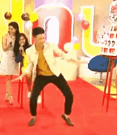 a man is dancing on a red carpet in front of a sign that says coca cola .