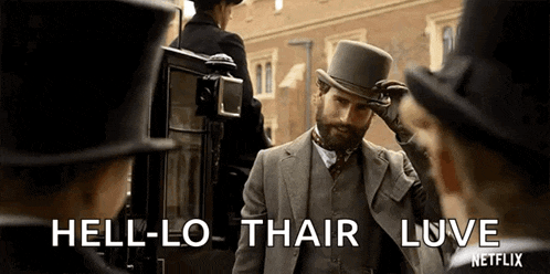 a man in a suit and top hat is standing in front of a group of men .