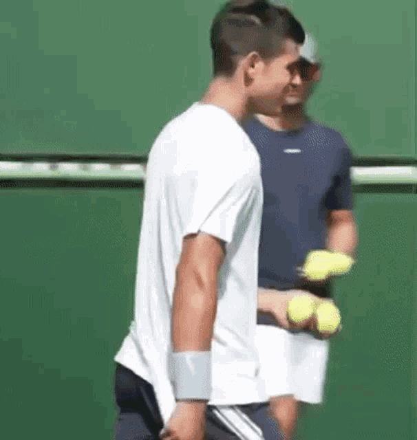 a man is holding a tennis racket on a tennis court .