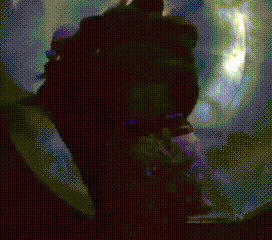 a person is standing in a dark room with a purple background