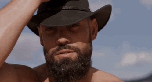 a man with a beard wearing a black cowboy hat
