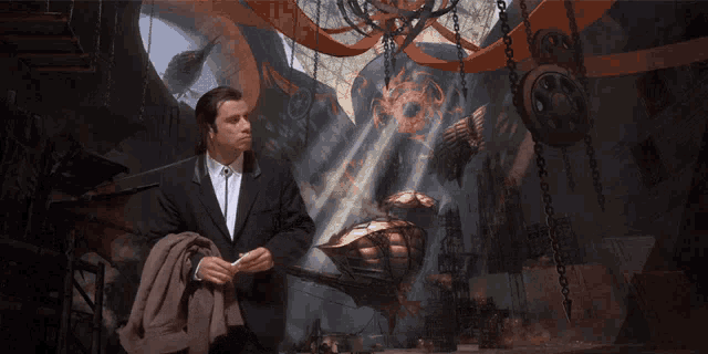 a man in a suit and tie is standing in front of a painting that says ' t.i. ' on it