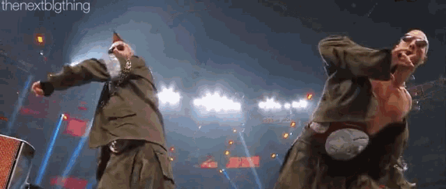 two men are dancing on a stage in front of a sign that says the nextbigthing