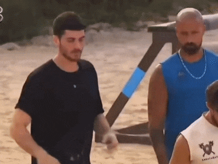 three men are standing next to each other on a beach .