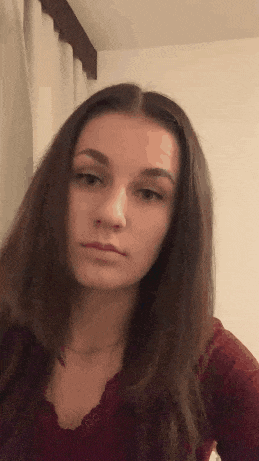 a young woman with long hair is making a funny face while looking at the camera .
