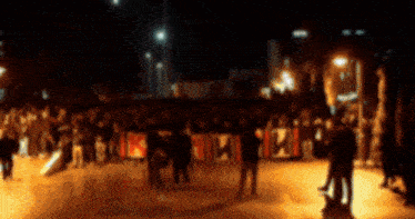 a blurry picture of a crowd of people holding a sign that says ' r.i.p. '
