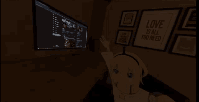 a computer monitor with a sign that says love is all you need