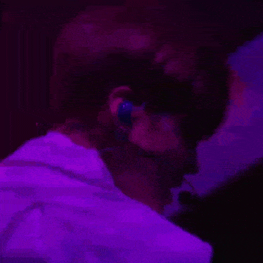 a close up of a person wearing headphones in a dark room