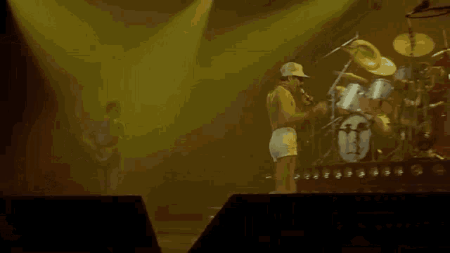 a man without a shirt is dancing on a stage in front of a microphone .