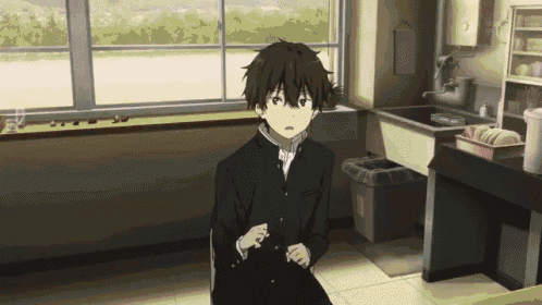 a boy is sitting in front of a window in a kitchen .