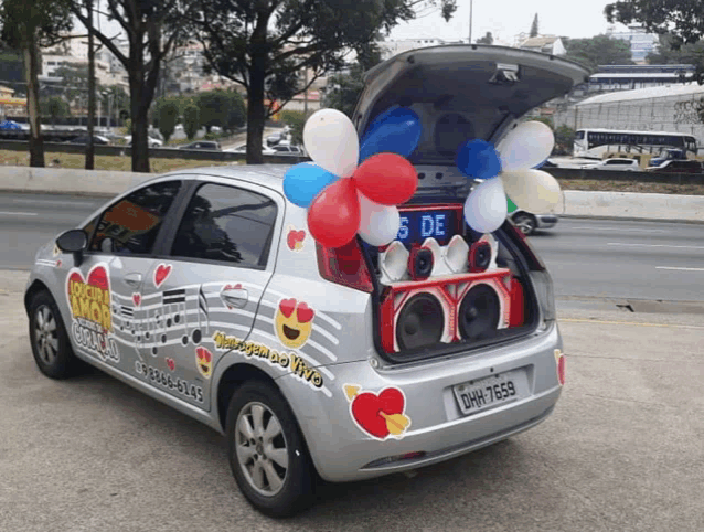 a silver car with balloons in the trunk and the license plate dhw-7699