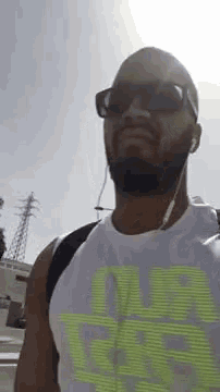 a man with a beard wearing sunglasses and ear buds .